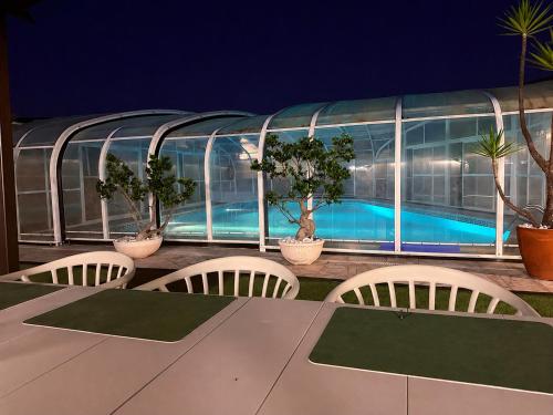 a table and chairs on a balcony with a swimming pool at Dii Beach House - Piscina Aquecida 28º-32º C in Torres Vedras