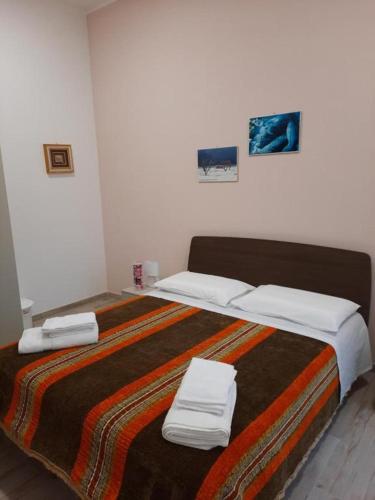 a bedroom with a large bed with towels on it at MARE FUORI - stanze con piscina in Monopoli