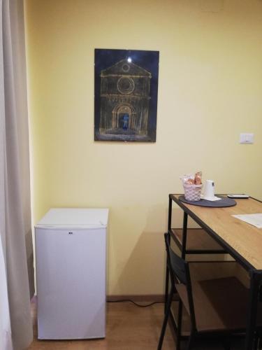 a small white refrigerator in a room with a table at Candelieri Suites in Sassari
