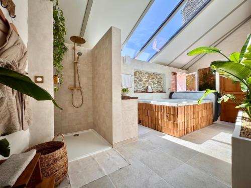 a bathroom with a shower and a bath tub at Le Pré de la Mer Suite & SPA Privatif in Querqueville