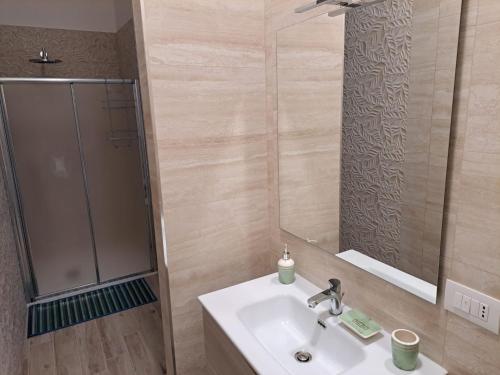 a bathroom with a sink and a mirror at MARE FUORI - stanze con piscina in Monopoli