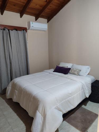 a bedroom with a large white bed with pillows at Casa con dos Dormitorios in Encarnación