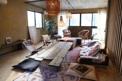 a living room with a wooden table and a couch at ゲストハウスよるよなか in Nagoya