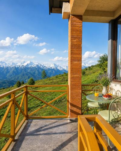 a balcony with a table and a view of mountains at Datvina Panorama Chalets Mravaldzali, Racha in Oni
