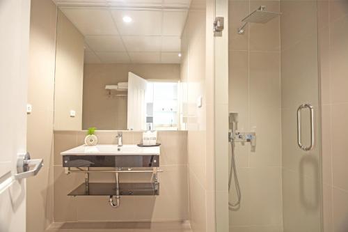 a bathroom with a sink and a shower at Hill Fresco Hotel in Pattaya South