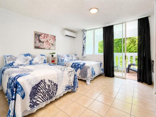 a bedroom with two beds with blue and white sheets at Golden Dream Studio 2nd floor B in Isabela