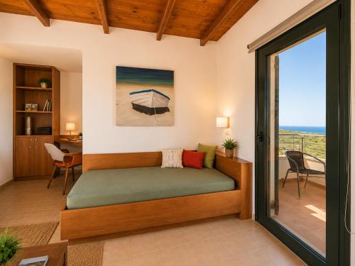 a room with a bed with a view of the ocean at Margarita's Villas in Chania