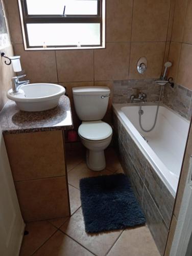 a bathroom with a toilet and a tub and a sink at Hibberdene See to Sea in Hibberdene