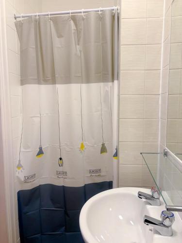 a bathroom with a shower curtain and a sink at Downshire House in Douglas
