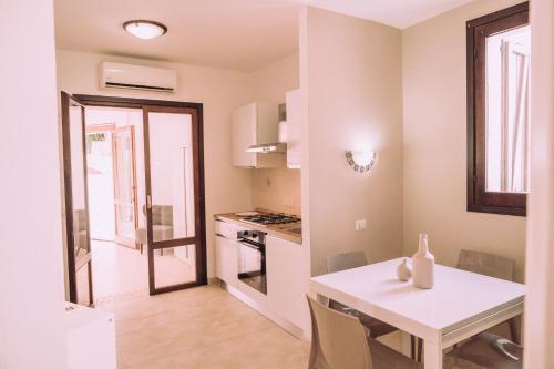 a kitchen and dining room with a white table at Appartamenti I Lentischi in Villasimius