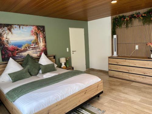 a bedroom with a large bed and a painting on the wall at Apartment Leidenberger - Nähe Rothenburg & Ansbach - 2 Schlafzimmern in Colmberg