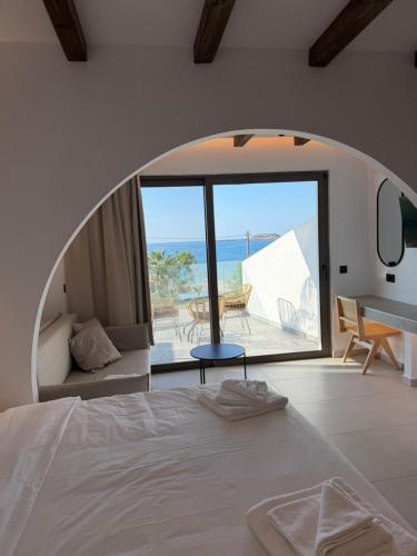 a bedroom with a bed and a view of the ocean at Salt and stone suites in Vrachonisída touArchangélou