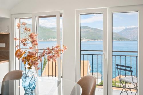 a dining room with a view of the water at Villa Bokeljka in Krašići
