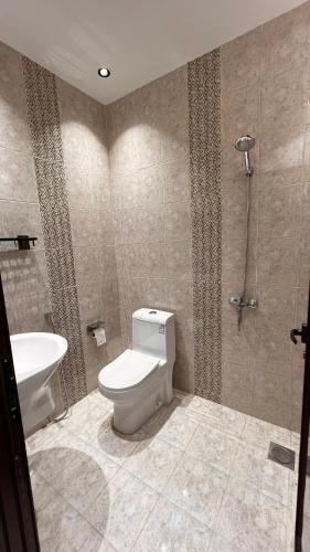 a bathroom with a toilet and a sink at شالية بمسبح وجلسة خارجية- غرفتين نوم وملحق خارجي ومدخل سيارة in Unayzah