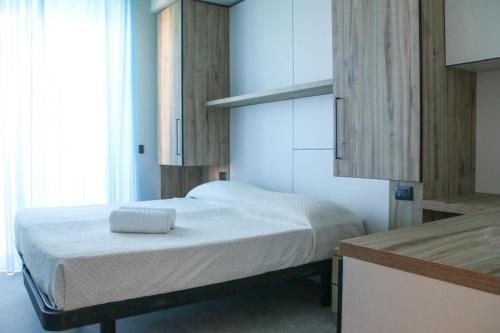 a small bedroom with a bed with white sheets at HOTEL BALTIC in Alba Adriatica