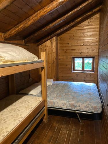 a bedroom with two bunk beds in a cabin at Baita Palue in Torcegno