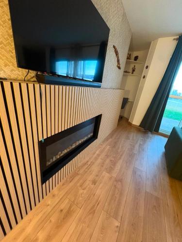 a living room with a fireplace and a flat screen tv at El Cubanito Athéna - Résidence de Standing - 2 Chambres - 4 Couchages - 8 Personnes Max - Parking Privé - Gare à 8 min in Cergy