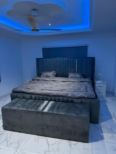 a large bed in a room with a blue light at Mavis Lodge in Janman
