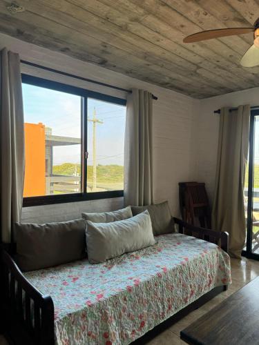 a bedroom with a bed and a large window at Las Pakas in La Paloma