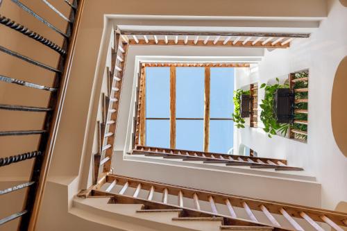 ein Treppenhaus mit Fenster in einem Haus in der Unterkunft Cal Roure Boutique Hotel in Igualada