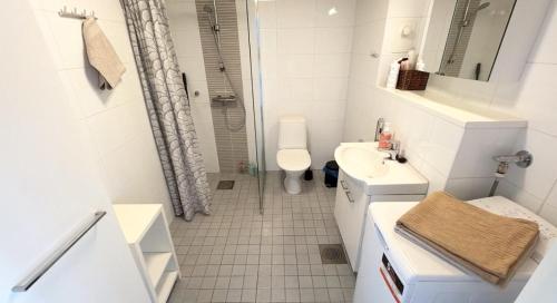 a white bathroom with a sink and a toilet at HHH Modern flat centrally located in Helsinki, close to Pasila railway station in Helsinki
