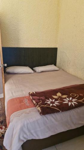 a bed in a corner of a room at Millys Guesthouse Jhb in Johannesburg