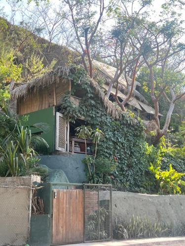 a small green house with a fence in front of it at Casa Alma in Sayulita