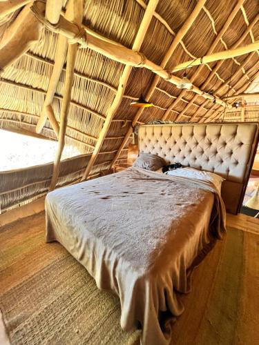 a bed in a room with a wooden ceiling at Casa Alma in Sayulita