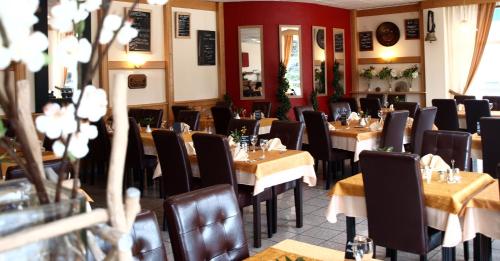 um restaurante com mesas e cadeiras num quarto em The Originals City, Hôtel du Faucigny, Cluses Ouest em Scionzier