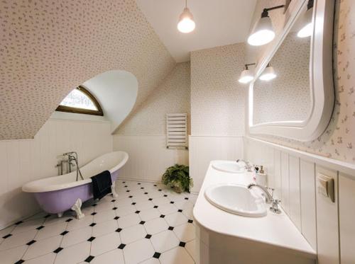 a bathroom with a tub and a sink and a bath tub at Dom pod strzechą in Swornegacie