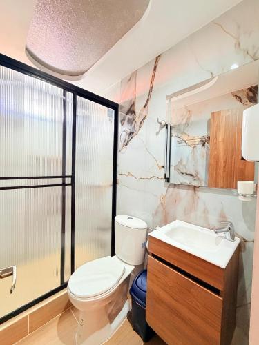 a bathroom with a toilet and a sink at Hospedaje Vista Hermosa Salento in Salento