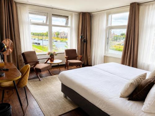 a hotel room with a bed and a table and chairs at Hotel de Zon - Brasserie Bresson by Flow in Ommen