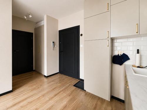 a bathroom with two black doors and a wooden floor at CudNajem Old Town Apartments - Bulvar in Elblag