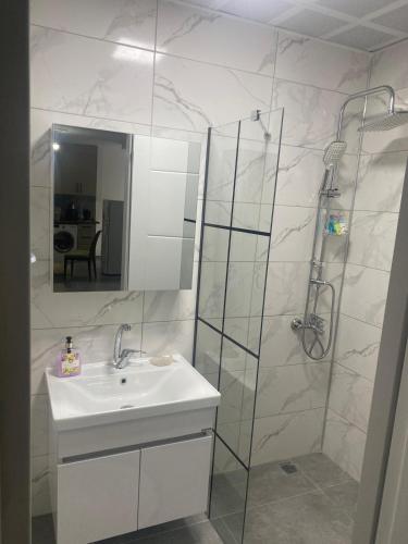 a bathroom with a sink and a shower with a mirror at Beyaz Kosk in Demre