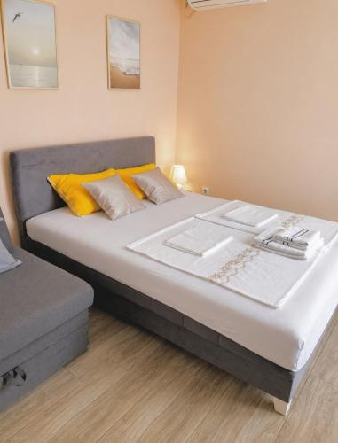 a bedroom with a large bed with yellow pillows at Gagin San -apartman na plaži in Veliko Gradište