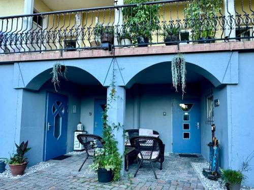 a patio with chairs and a balcony with blue doors at Vila Kralj in Podčetrtek