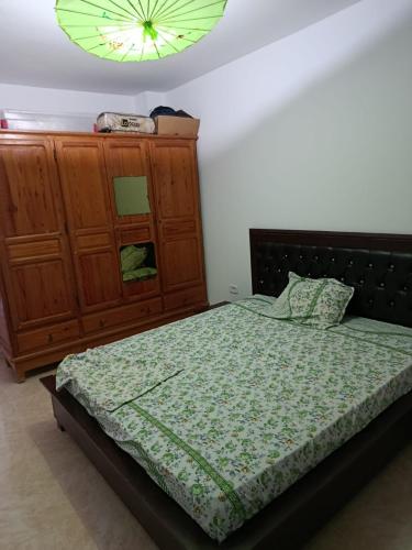 a bedroom with a bed and a wooden dresser at Résidence de la mer in Île Pilau
