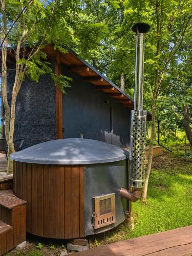 an outdoor hot tub with a stove in a yard at DEIVID house for rent in Skulte