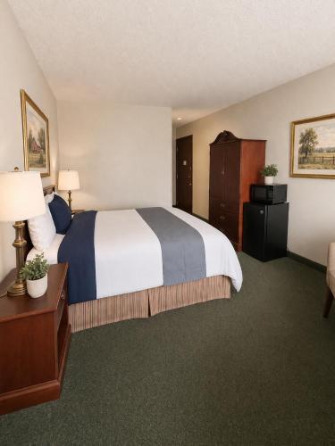a hotel room with a large bed and a desk at The Jeffreys Hotel Extended Stay in Osceola