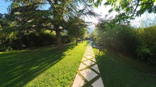 a path in a park with trees and grass at Papillon 05 - Wellness - 6 Pers - Sauna - Jacuzzi - Yoga - Petanque - Parking in Briançon