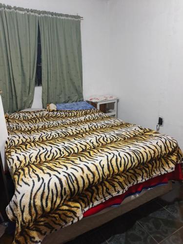 a bed with a zebra blanket on it in a room at Departamento 1 habitación in San Salvador de Jujuy