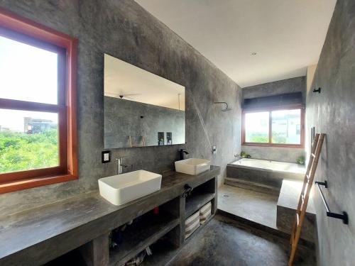 a bathroom with two sinks and a tub and a mirror at Private luxury villa in Holbox Island