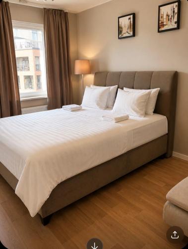 a large bed with white sheets and pillows in a bedroom at Nordhaven Sundbyberg in Sundbyberg