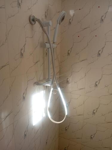 a shower head in a bathroom with a marble wall at Home Away From Home in Nadi
