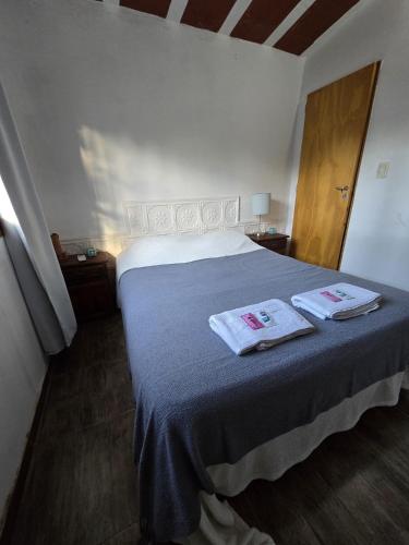 a bedroom with a bed with two towels on it at La Chiquitita in Villa Dolores