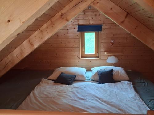 a bed in the attic of a log cabin at Ádova chatová osada in Úbislav