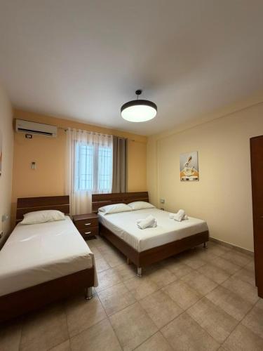 a bedroom with two beds and a light at Shengjin Central Apartments in Shëngjin