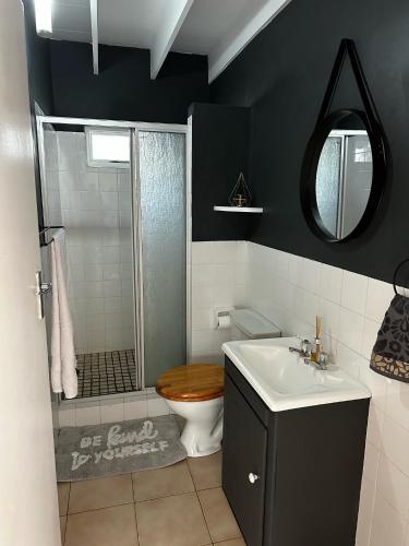 a bathroom with a shower and a toilet and a sink at Happy Place in Grotto Bay