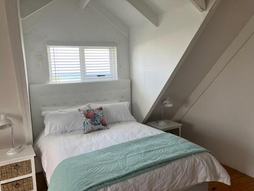 a small bedroom with a bed and a window at Happy Place in Grotto Bay