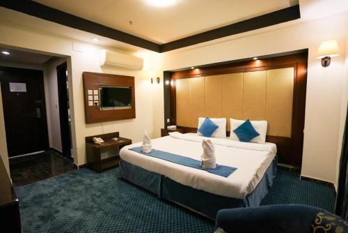 a hotel room with a large bed with blue pillows at فندق برج السيف in Mecca